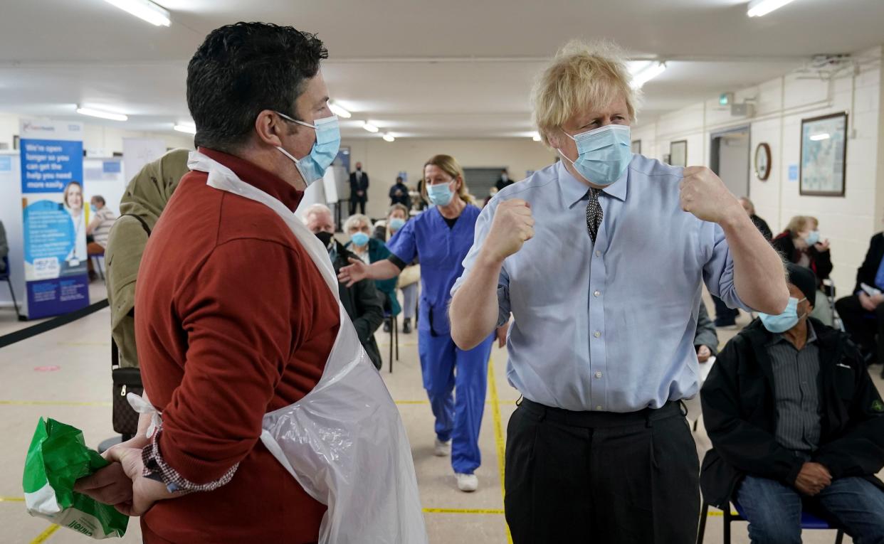 Prime Minister Boris Johnson talks to Christopher Nicholls who suffered from COVID-19 at the same time as Johnson, as he visits a COVID-19 vaccination center in Batley, on Feb. 1, 2021, in West Yorkshire, England.