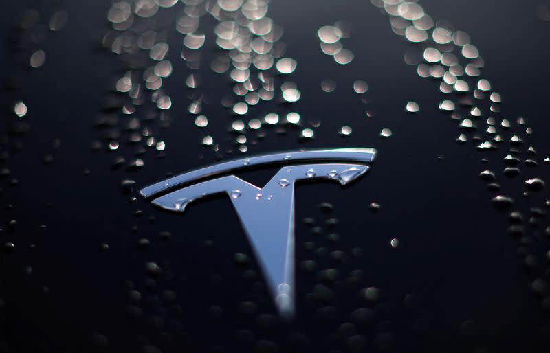 Raindrops are seen on the bonnet of a used Tesla electric car outside the showroom of a used car dealer in Manchester