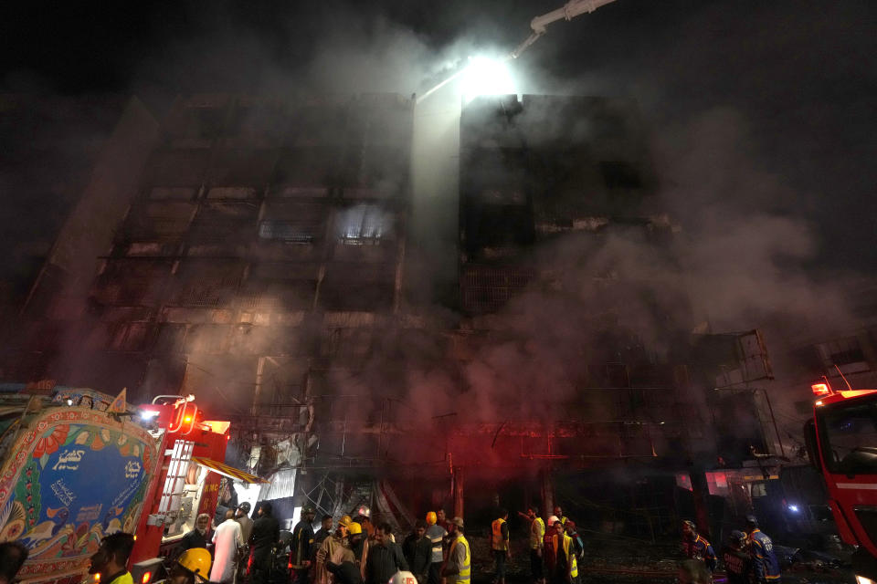 Firefighters struggle to control a fire at a multi-story commercial building in Karachi, Pakistan, Wednesday, Dec. 6, 2023. A massive fire broke out Wednesday in a multi-story commercial building in Pakistan's largest southern port city of Karachi, killing a number of people and damaging several shops, police and rescue officials said. (AP Photo/Fareed Khan)