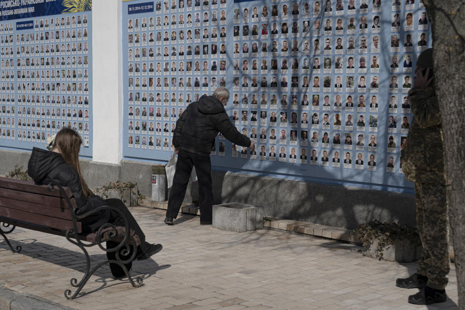 A man stands in front of the Memory Wall of Fallen Defenders of Ukraine in Russian-Ukrainian War on Ukrainian Volunteer Day in Kyiv, Ukraine, Tuesday, March 14, 2023. (AP Photo/Andrew Kravchenko)