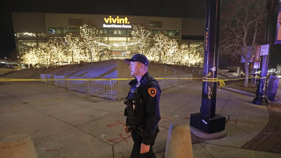 A Salt Lake City police officer stands guard in front of Vivint Smart Home Arena after the Utah Jazz's home had been evacuated because of a suspicious package following the team's NBA basketball game against the Golden State Warriors on Friday, Nov. 22, 2019, in Salt Lake City. Most fans had already left the building when players, coaches and reporters were instructed to leave the arena following Utah's 113-109 victory. (AP Photo/Rick Bowmer)