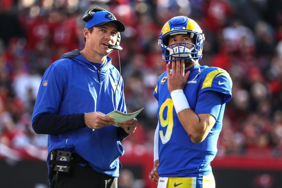 Rams quarterbacks coach Zac Robinson talks with Matthew Stafford.