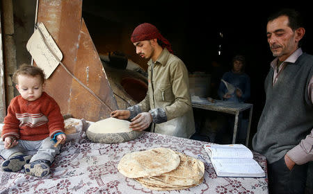 A man makes bread in the town of Hamoria, eastern Ghouta in Damascus, Syria, November 29, 2017. REUTERS/Bassam Khabieh