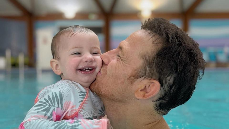 father swimming with baby daughter 