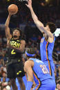 Utah Jazz guard Collin Sexton, left, shoots against Oklahoma City Thunder forward Chet Holmgren, right, and guard Aaron Wiggins during the second half of an NBA basketball game Wednesday, March 20, 2024, in Oklahoma City. (AP Photo/Kyle Phillips)