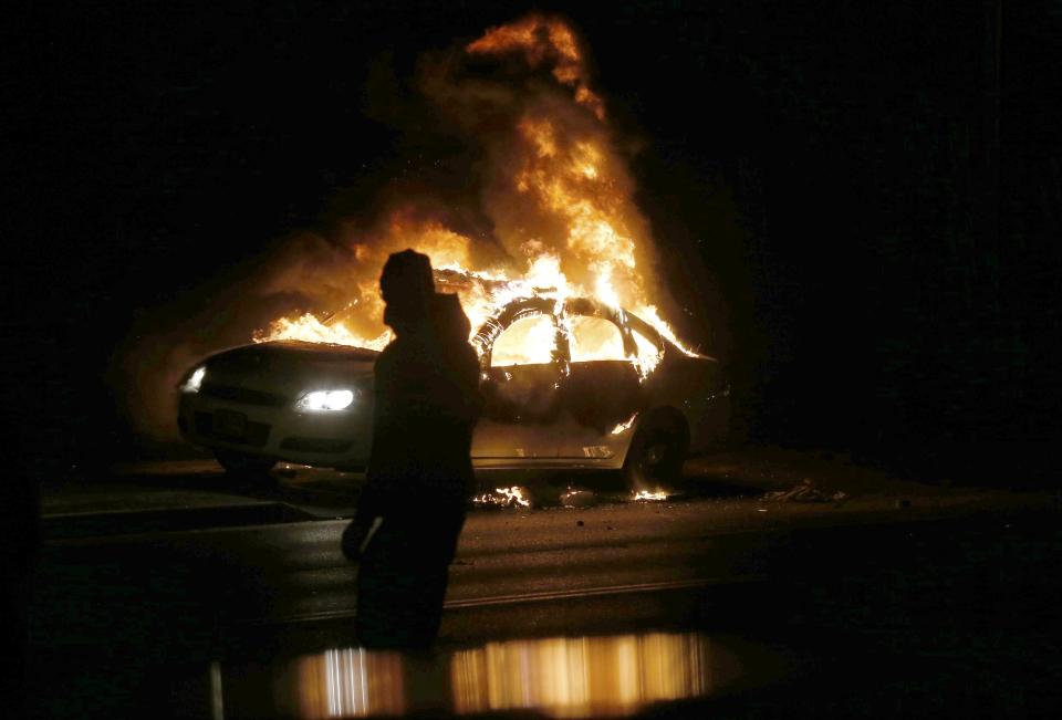 A car burns on the street after a grand jury returned no indictment in the shooting of Michael Brown in Ferguson, Missouri