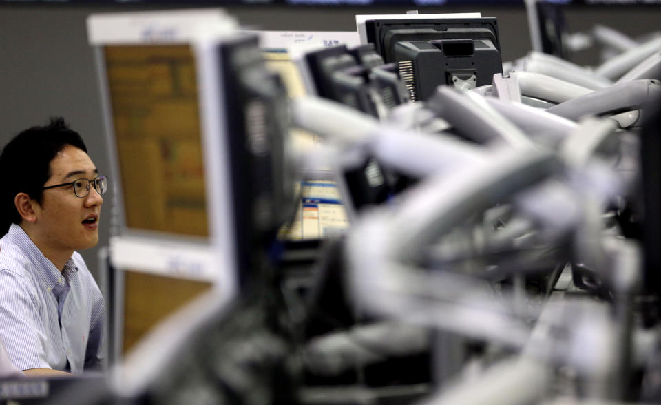 A currency trader looks at the monitors near a screen showing the Korea Composite Stock Price Index (KOSPI) at the foreign exchange dealing room of the Korea Exchange Bank headquarters in Seoul, South Korea, Friday, Sept. 7, 2012. Asian stock markets rallied Friday, boosted by strong advances on Wall Street and a highly anticipated plan to assist debt-riddled countries in the eurozone. (AP Photo/Lee Jin-man)