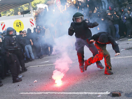 German riot policemen catch a protester during demonstrations. REUTERS/Kai Pfaffenbach