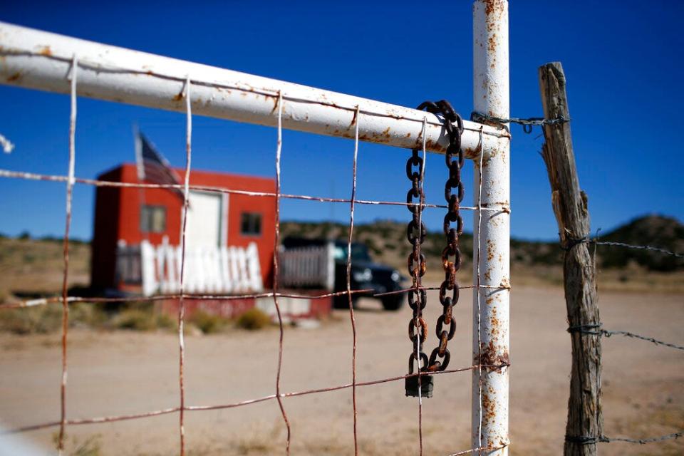 A rusted chain hangs on the fence at the entrance to the Bonanza Creek Ranch film set in Santa Fe on Wednesday, Oct. 27, 2021. New Mexico authorities said they have recovered a lead projectile believed to have been fired from the gun used in the fatal movie-set shooting.