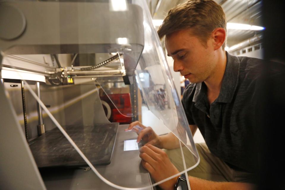 Jordan Fernandes sets up one of the new 3D printers at the new ProtoXYZ offices at the DeMello International Center on Union Street in New Bedford.