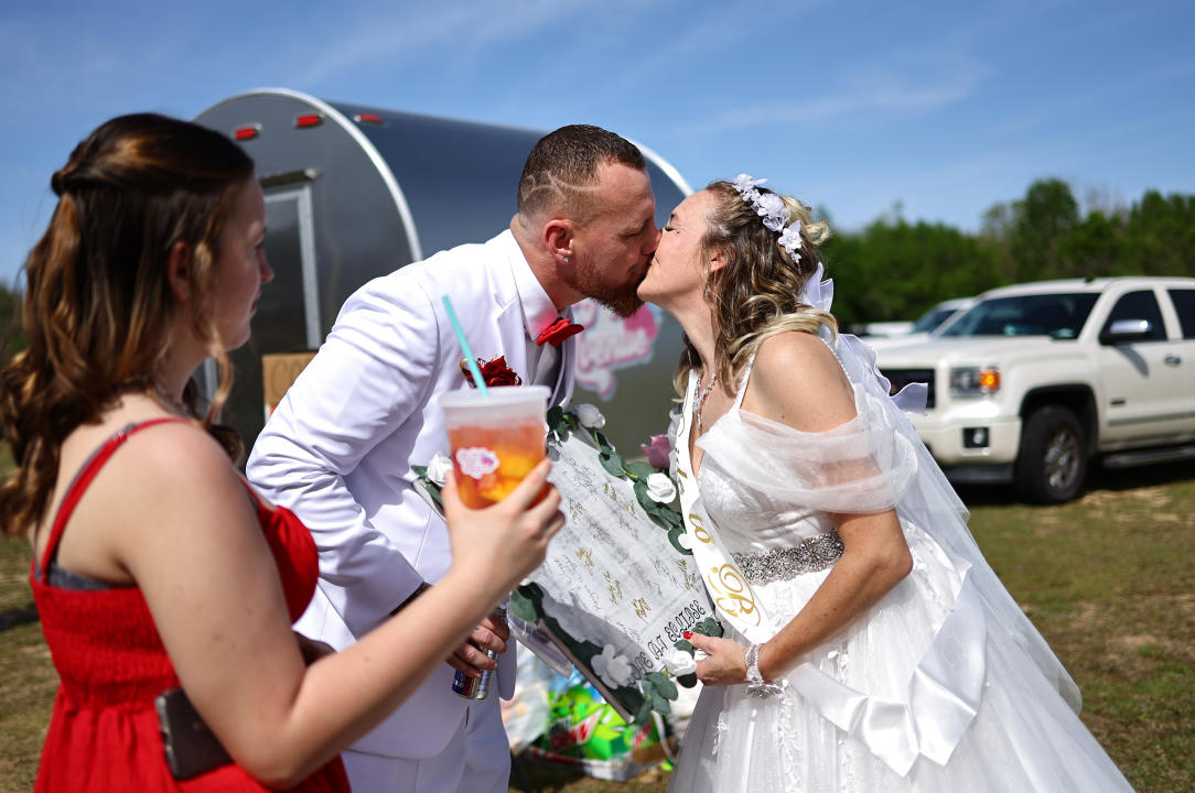 A bride and groom kiss before an outdoor mass wedding in Russellville, Arkansas. 