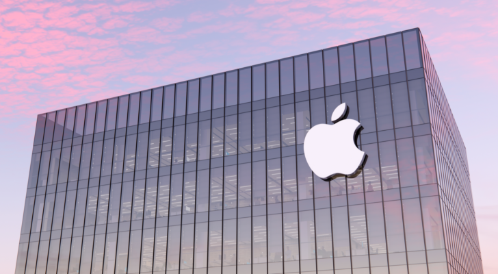 An image of a building with the Apple logo on it, a pink sunset in the background