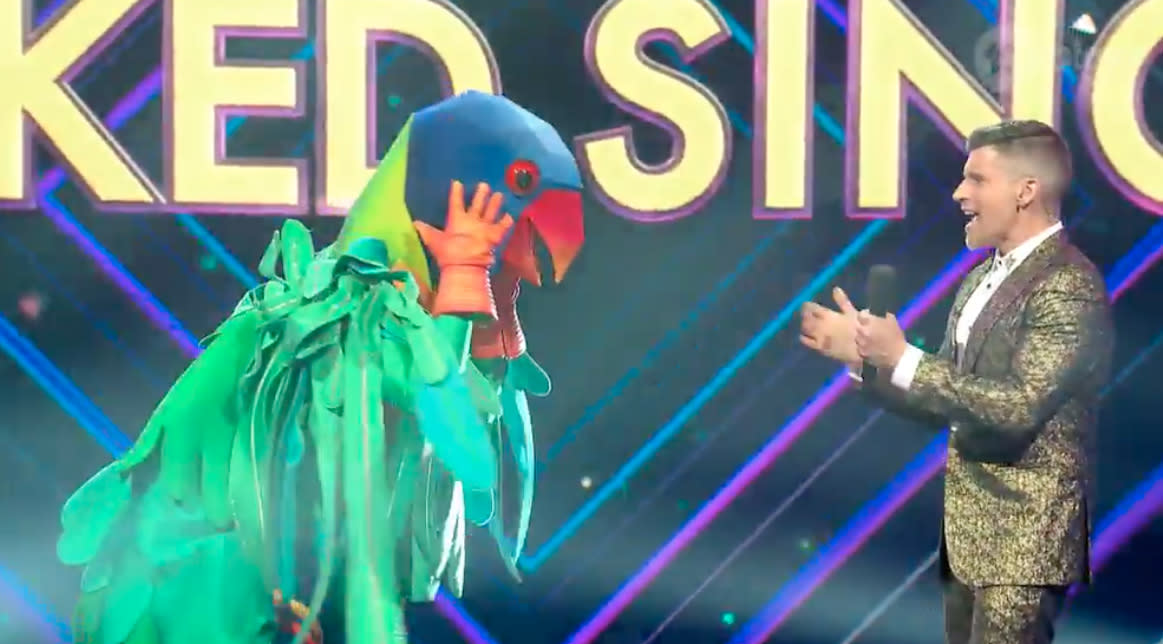 The Masked Singer AU The Parrot removes his headdress, host Osher Gunsberg watches on