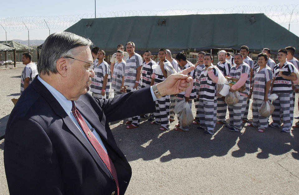 FILE - In this Feb. 4, 2009, file photo, Maricopa County Sheriff Joe Arpaio, left, orders approximately 200 convicted illegal immigrants handcuffed together and moved into a separate area of Tent City, for incarceration until their sentences are served and they are deported to their home countries, in Phoenix. Documents obtained by The Associated Press show a court-appointed investigator concluded that high-ranking managers for former metro Phoenix Sheriff Joe Arpaio disregarded a federal judge's order to halt immigration sweeps targeting Latinos.The investigator also found an internal investigation was whitewashed to shield them from accountability. (AP Photo/Ross D. Franklin, File)