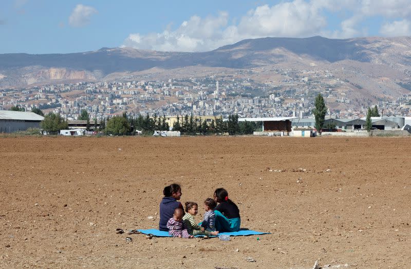 FILE PHOTO: Syrian refugees sit near an informal camp, in the Bekaa Valley