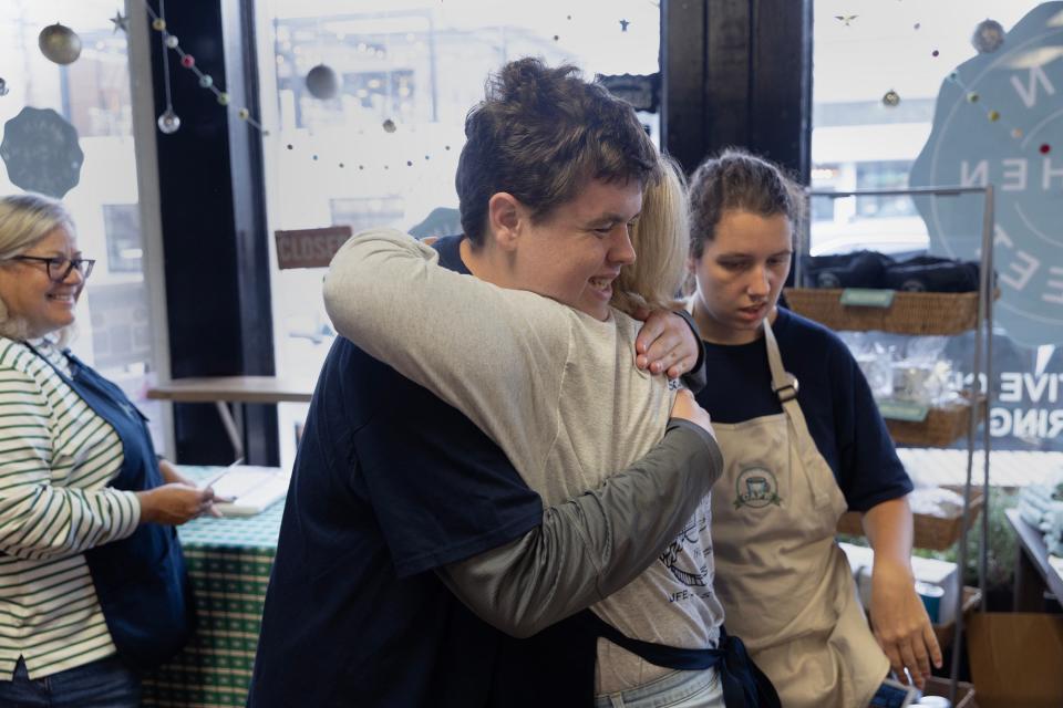 Ryan Prince of Wall gives a volunteer a hug as he takes over taking customers order as they come in. Kindness Café in Manasquan, which operates out of Main Street Kitchen three mornings per week, employs a staff of young adults with developmental disabilities.