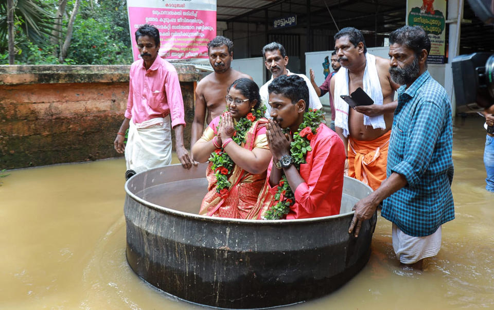 Akash and Aishwarya, an Indian couple who arrived for their wedding in unusual style after sailing through the flooded streets of their town in a cooking pot, Kerala state, India. (Gopan Velu Photo)