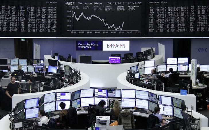 Traders work at their desks in front of the German share price index, DAX board, at the stock exchange in Frankfurt, Germany, February 9, 2016. REUTERS/Staff/Remote