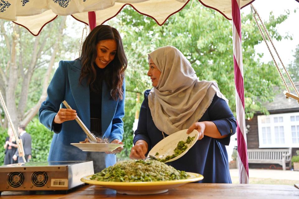 <p>Meghan's first solo endeavor as the Duchess of Sussex is a project that combines two of her passions: food and empowering women. Here she is helping to serve up lunch at the launch of the <em><a rel="nofollow noopener" href="https://www.amazon.com/Together-Community-Cookbook-Hubb-Kitchen/dp/1984824082" target="_blank" data-ylk="slk:Together;elm:context_link;itc:0;sec:content-canvas" class="link ">Together </a></em><a rel="nofollow noopener" href="https://www.amazon.com/Together-Community-Cookbook-Hubb-Kitchen/dp/1984824082" target="_blank" data-ylk="slk:cookbook;elm:context_link;itc:0;sec:content-canvas" class="link ">cookbook</a><em>. </em></p>