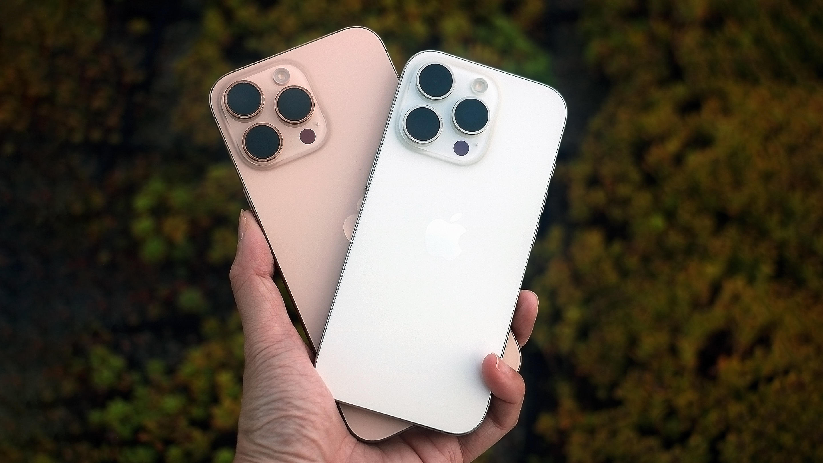 The iPhone 16 Pro and iPhone 16 Pro Max held in mid air with their backs facing up.