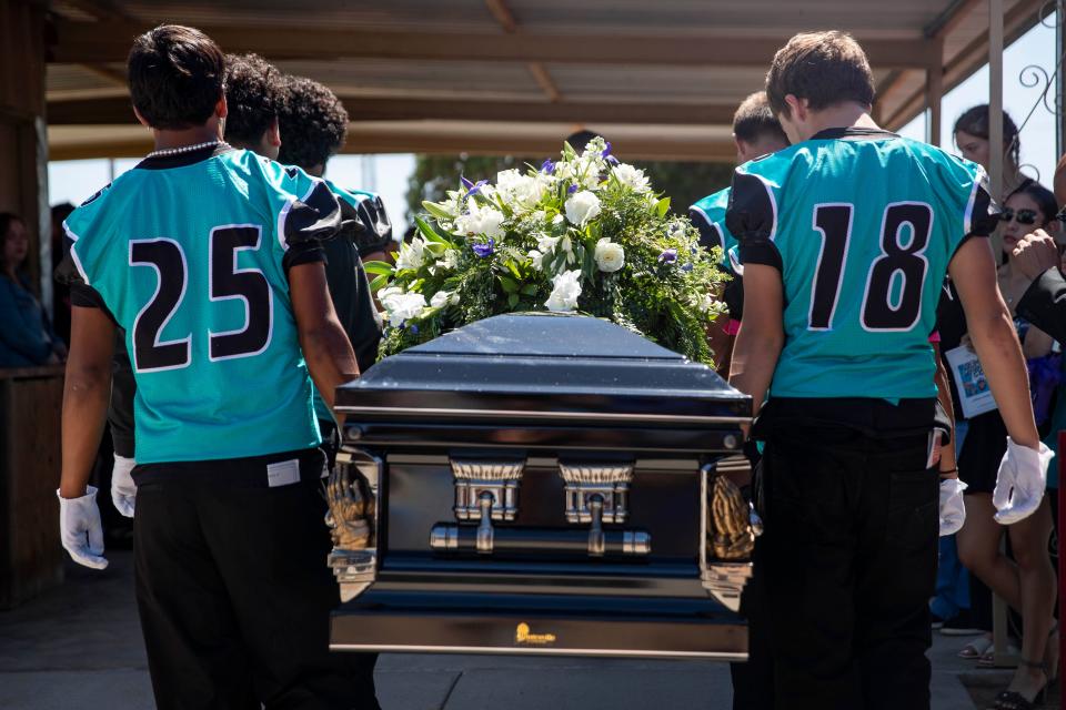 Organ Mountain High School football players carry Abraham Romero’s casket to his gravesite at St. Joseph's Cemetery in Las Cruces on Saturday, Sept. 24, 2022.