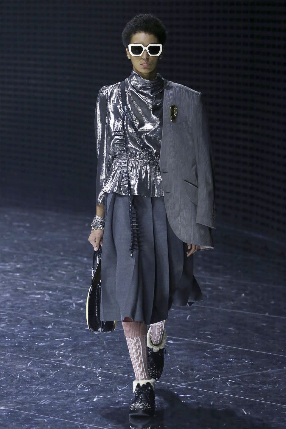 <p>Alessandro Michele has been a breakout star in the fashion realm, but that hasn't made him immune to controversy. The designer has handled his missteps-specifically racially charged imagery on his runway, head-on, which could make the designer's inspiration of masks somewhat confounding. The show notes reference Hannah Arendt's 1958 book "The Human Condition." Specifically, Arendt "reminds us that we are persons when we choose the mask through which we appear on the world's stage...as a distinct and unique being among equals," says Arendt. </p><p>So perhaps, Michele is making a statement about the equality of humanity-how that plays into spiked collars, houndstooth suiting, Gucci logo knee pads, sweater dresses, and a '70s inspired tiger print coat remains a mystery. But Gucci's legions of fans will be pleased to see more, new Michele statements to invest in on today's runway. <em>-Kerry Pieri</em></p>