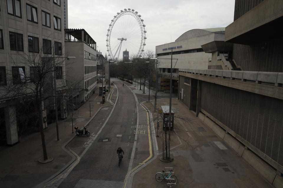 Big Ben's clock tower and the London Eye ferris wheel stand in the distance as the area around Royal Festival Hall is very quiet in London, Wednesday, April 8, 2020. The new coronavirus causes mild or moderate symptoms for most people, but for some, especially older adults and people with existing health problems, it can cause more severe illness or death. (AP Photo/Matt Dunham)