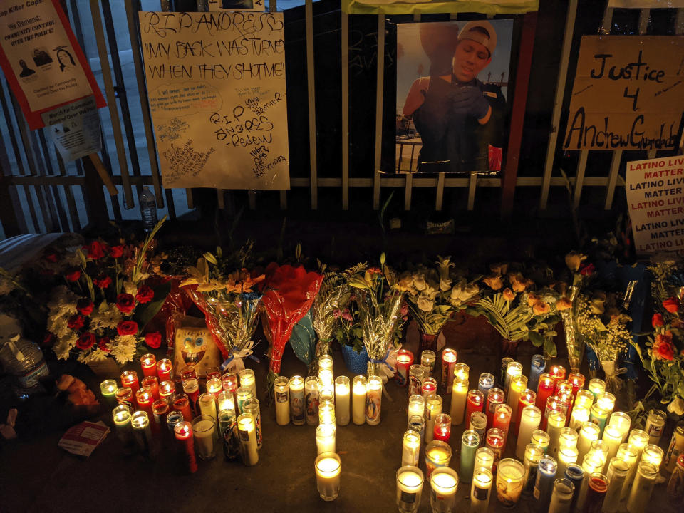 Candles and flowers are set next to an image of Andres Guardado. (Photo: AP Photo/Damian Dovarganes)