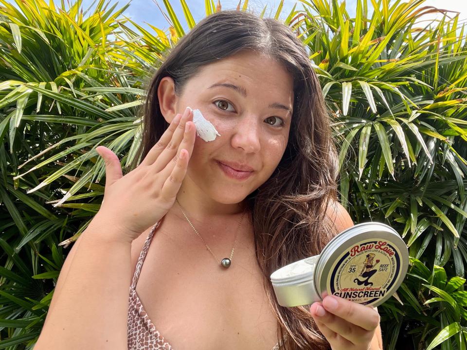 Ashley Probst putting sunscreen on her cheeks