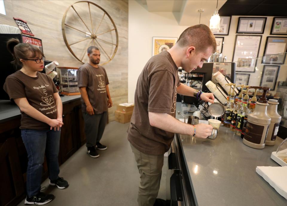 Barista Jake Loerker prepares a coffee drink at Sleepy Coffee, Too, in Sleepy Hollow, April 23, 2024. Looking on are barista Ella Manfredi and assistant manager Sherman Lawrence.