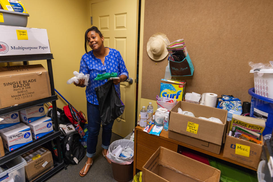 Briana Martin, drop-in center manager at Covenant House, shows the bags of hygienic products that are handed out to at-risk populations in Charleston. The green bag is for people to use to clean up their own waste. (Photo: Craig Hudson for HuffPost)