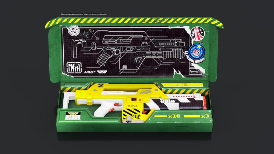 A yellow Aliens Nerf Gun inside a green box with the top opened