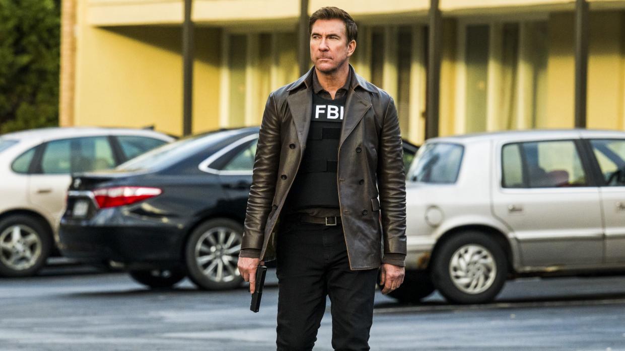  Dylan McDermott as Supervisory Special Agent Remy Scott in a leather coat with a gun in FBI: Most Wanted season 5. 