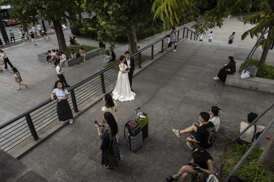 Una pareja de recién casados se toma fotos con sus padres cerca del Bund en Shanghái, China, el 5 de julio de 2023. (Qilai Shen/The New York Times).