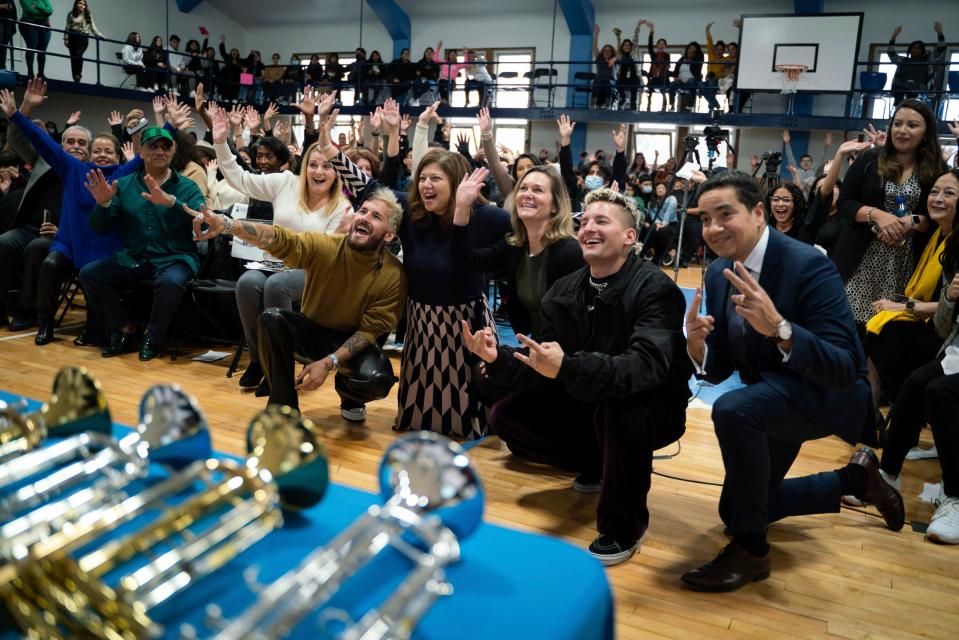 Singer-songwriter brothers Ricardo Andrés "Ricky" Reglero Rodriguez and Mauricio Alberto "Mau" Reglero Rodriguez from the band Mau Y Ricky, pose for a photo with faculty and students at Academy of the Americas in Detroit on Dec. 8, 2022.