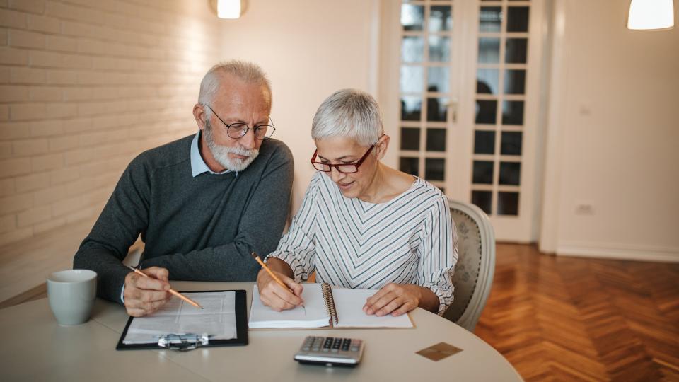 A senior couple taking a closer look at their budget in the comfort of their home.