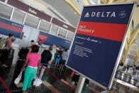 Passengers wait in line to check in after Delta Air Lines computer systems crashed leaving passengers stranded at airports around the globe as flights were grounded at Ronald Reagan Washington National Airport in Washington, U.S., August 8, 2016. REUTERS/Joshua Roberts