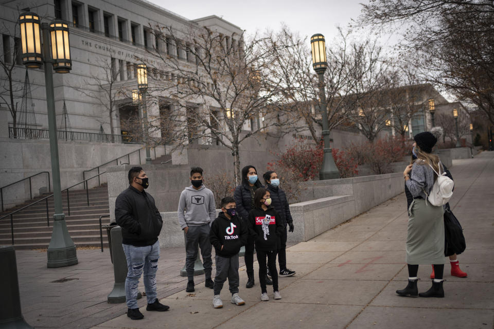 Members of The Church of Jesus Christ of Latter-day Saints speak to tourists around Temple Square in Salt Lake City, Sunday, Nov. 15, 2020. While the church has traditionally been overwhelmingly conservative and Republican, today there's also an increasingly large strain of liberal members. The church has also begun to directly address its history of racism, including a ban on Black priests that it lifted four decades ago. (AP Photo/Wong Maye-E)