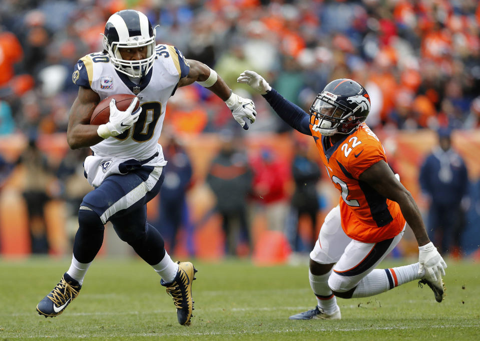 Los Angeles Rams running back Todd Gurley (30) breaks free from Denver Broncos defensive back Tramaine Brock (22) for a touchdown during the second half of an NFL football game, Sunday, Oct. 14, 2018, in Denver. (AP Photo/Joe Mahoney)