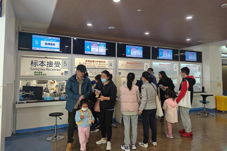 Parents take their children to see a doctor at the emergency department of a hospital in Shanghai. (PA)