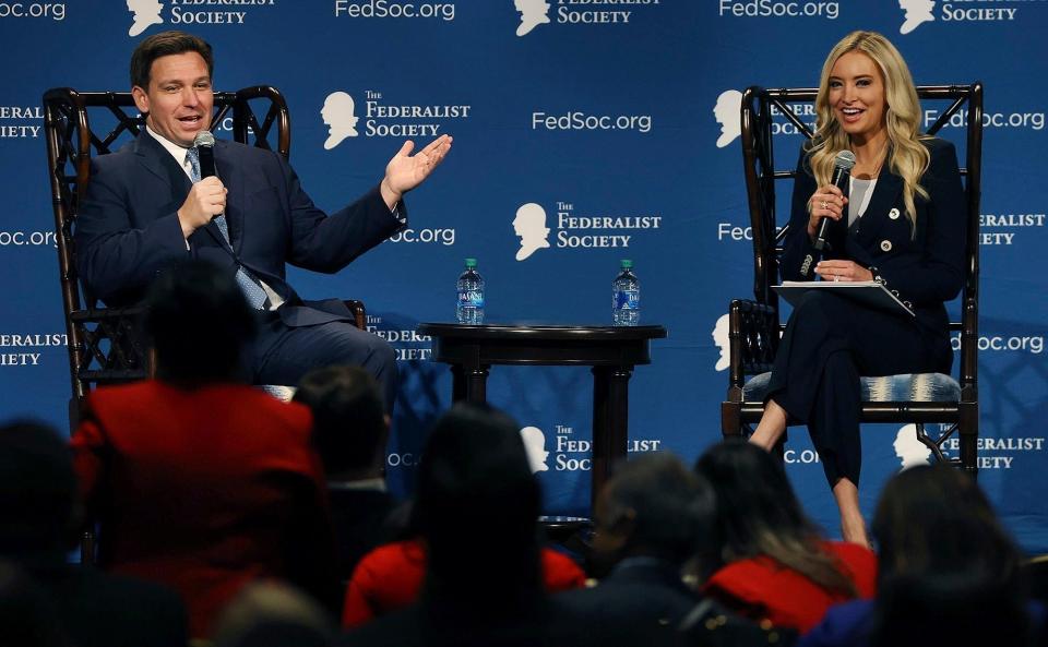 Florida Governor Ron DeSantis, left, and former White House press secretary Kayleigh McEnany speak during a “fireside chat” at the Florida chapter of the Federalist Society’s annual meeting at Disney’s Yacht Club resort in Walt Disney World on Friday, Feb. 4, 2022, in Lake Buena Vista, Fla.