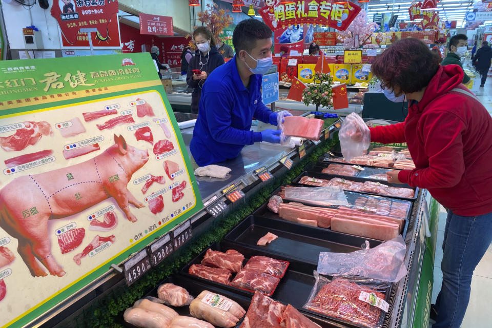 An employee attends to a customer at a supermarket in Beijing, China, Wednesday, Nov. 3, 2021. A recent seemingly innocuous government recommendation for Chinese people to store necessities for an emergency quickly sparked scattered instances of panic-buying and online speculation of imminent war with Taiwan. (AP Photo/Ng Han Guan)