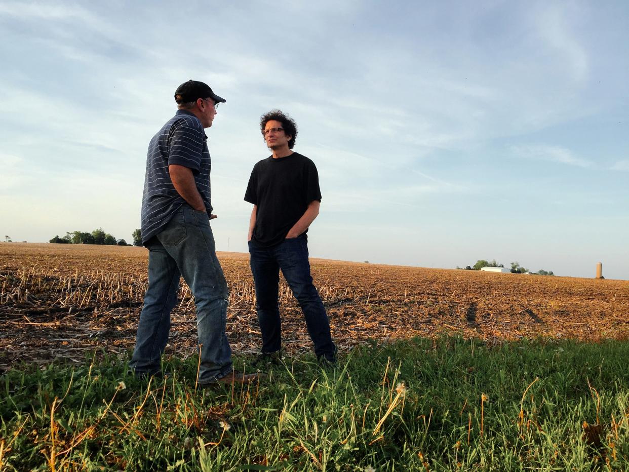 Photographer Anthony Suau, right, talks to a farmer on a farm in northern Illinois.