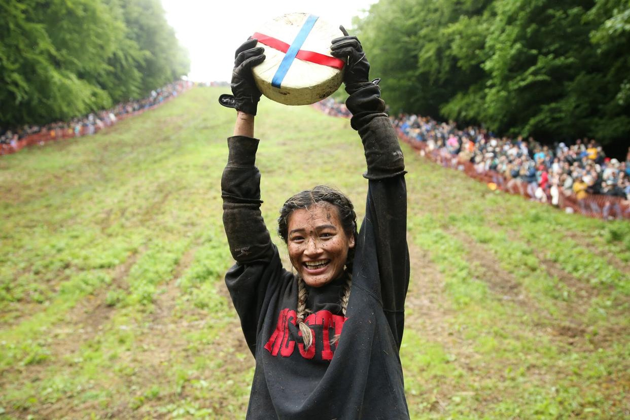 Abby Lampe from North Carolina celebrates her win with the cheese in the woman's race on June 05, 2022 in Gloucester, England