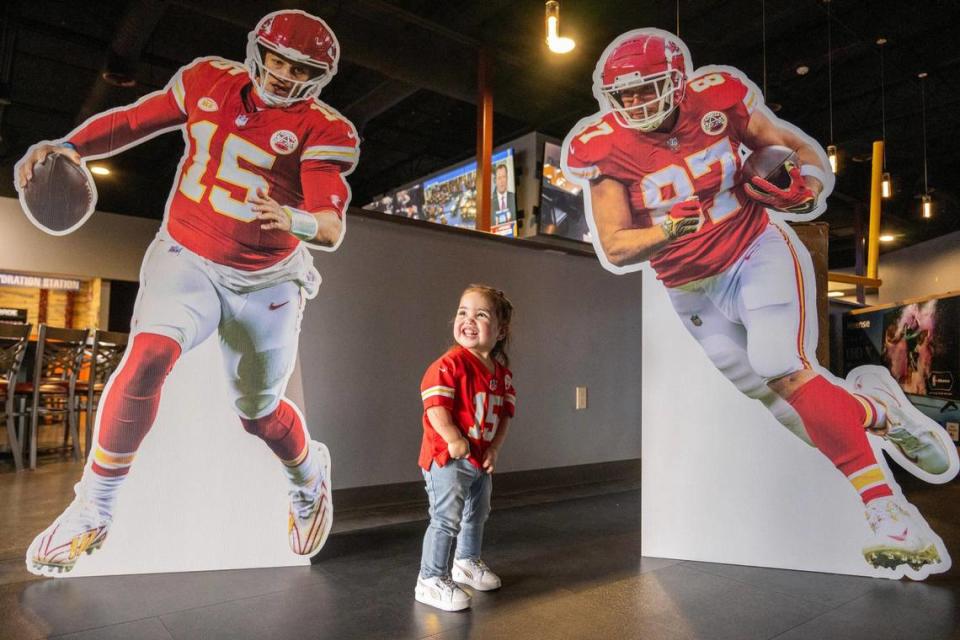 Two-year-old Elise Romero, whose parents Jazmine and Samuel are Kansas City Chiefs fans, smiles Wednesday as she poses with life-size cutouts of Kansas City Chiefs quarterback Patrick Mahomes and tight end Travis Kelce in Albuquerque, New Mexico. Emily Curiel/ecuriel@kcstar.com