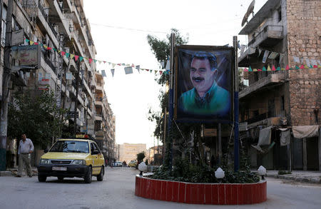 A car passes by a picture of the Kurdish leader Abdullah Ocalan of the Kurdistan Workers Party (PKK) in Aleppo's Sheikh Maqsoud neighbourhood, Syria July 15, 2017. REUTERS/Omar Sanadiki