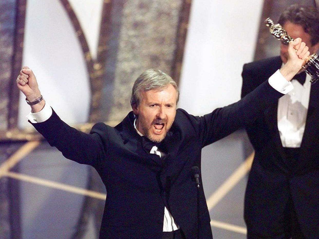 Director James Cameron raises his Oscar after winning in the Best Director Category during the 70th Academy Awards at Shrine Auditorium 23 March. Cameron won for his movie "Titanic."