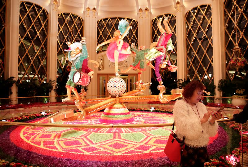 A woman rest next to the decoration inside the Wynn Palace casino resort in Macau