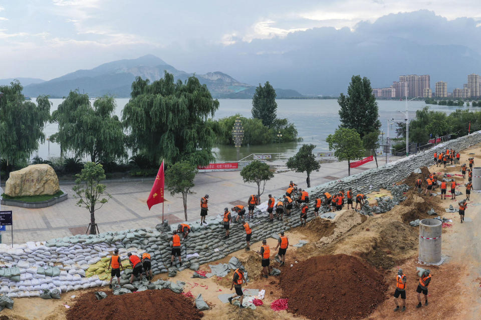 Chinese soldiers build a temporary embankment to contain Poyang Lake which has reached a record level threatening to flood Lushan city in central China's Jiangxi province Monday, July 13, 2020. Chinese authorities forecasted heavy rain across a wide swath of the country prompting evacuation of residents and raising emergency alerts levels. (Chinatopix via AP)