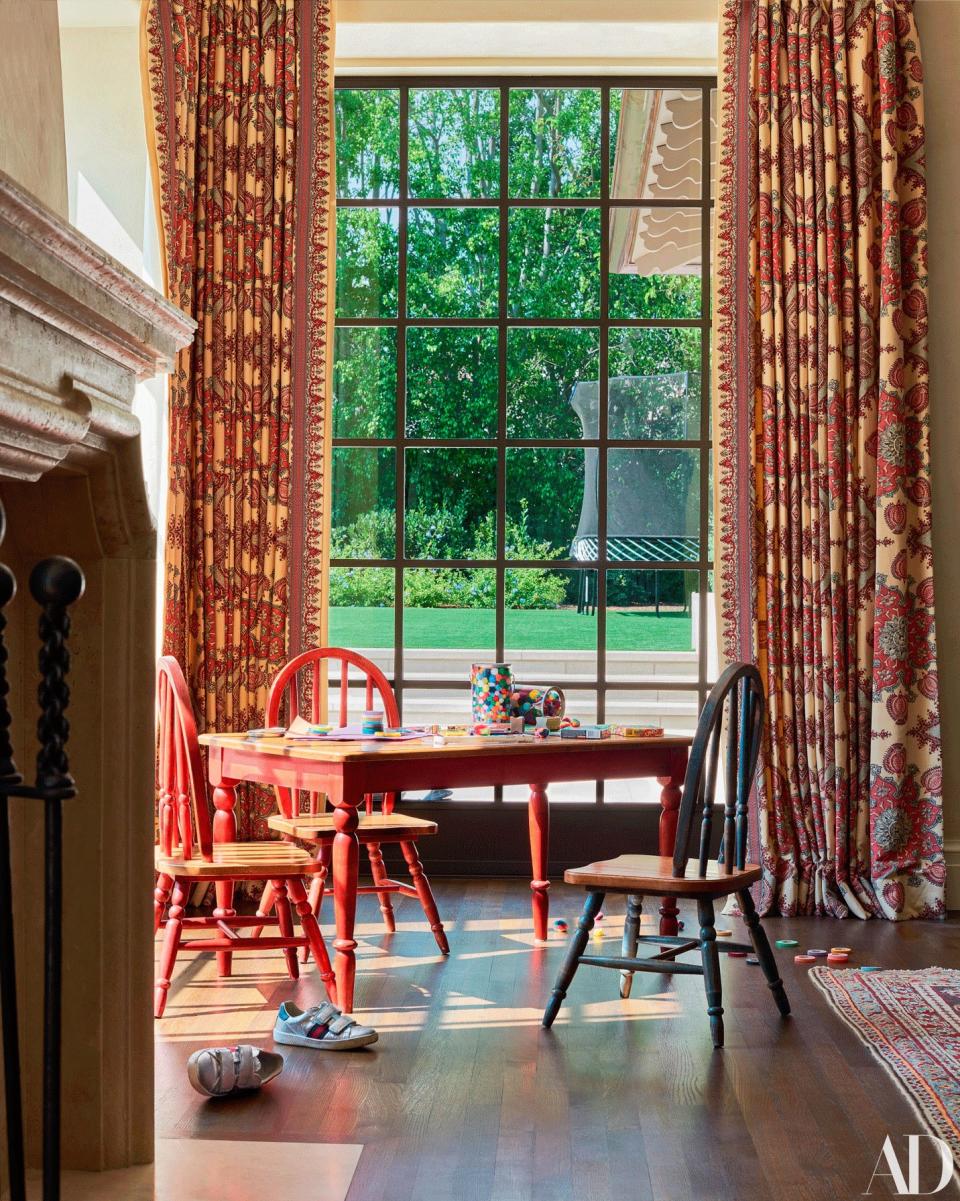 Curtains of a printed linen by Pierre Frey hang in the family room. Table and chairs by FAO Schwarz.